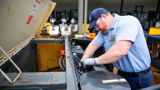 Worker Repairing a Forklift