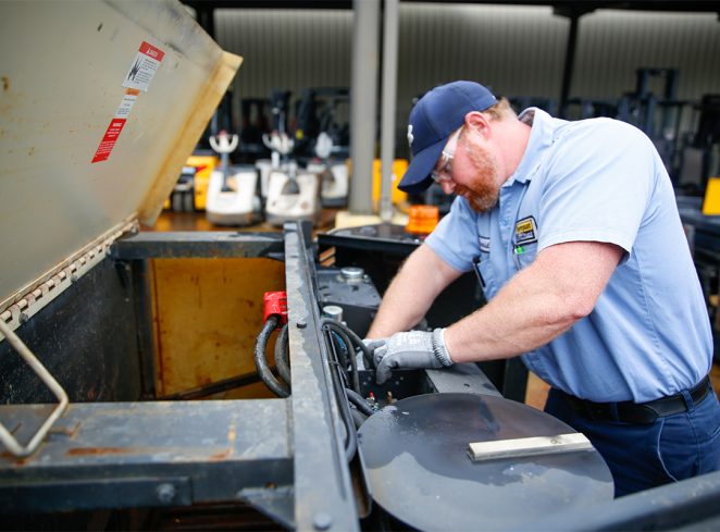 Worker Repairing a Forklift