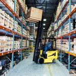 Forklift lifting a load to a high shelf