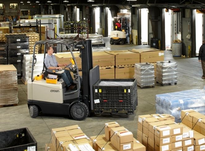 Crown forklift operating in a warehouse, efficiently moving pallets and materials - Thompson Lift Truck