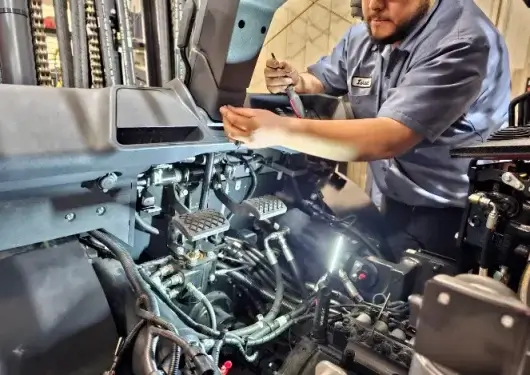Technician repairing forklift components for Florida forklift service and parts at Thompson Lift Truck