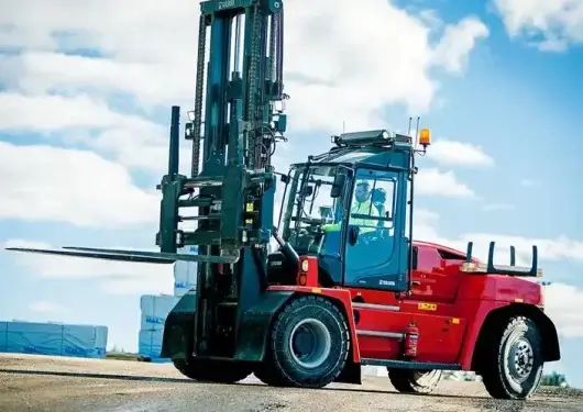 A heavy-duty red industrial forklift sits in an outdoor equipment yard, highlighting the rugged design and high capacity required for timber forklifts.